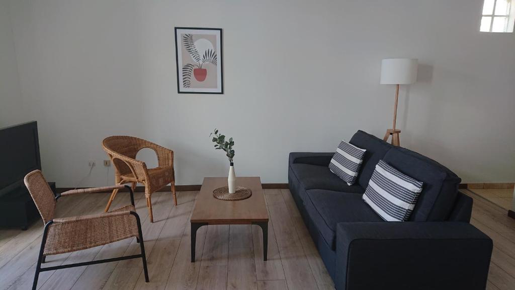 un salon avec un canapé bleu et une table dans l'établissement L'Amaryllis, beau T4 contemporain et lumineux en Centre Ville 3 étoiles, à Sète