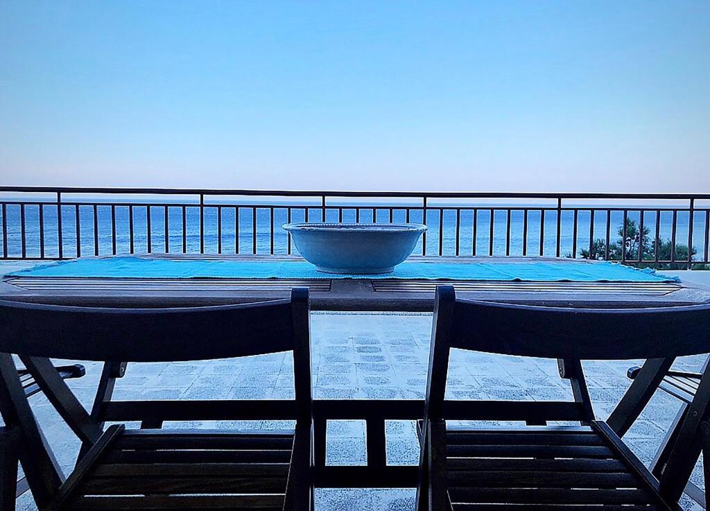 - une table avec deux chaises et un bol sur le balcon dans l'établissement Villa Astraea Kyra Panagia, à Kyra Panagia