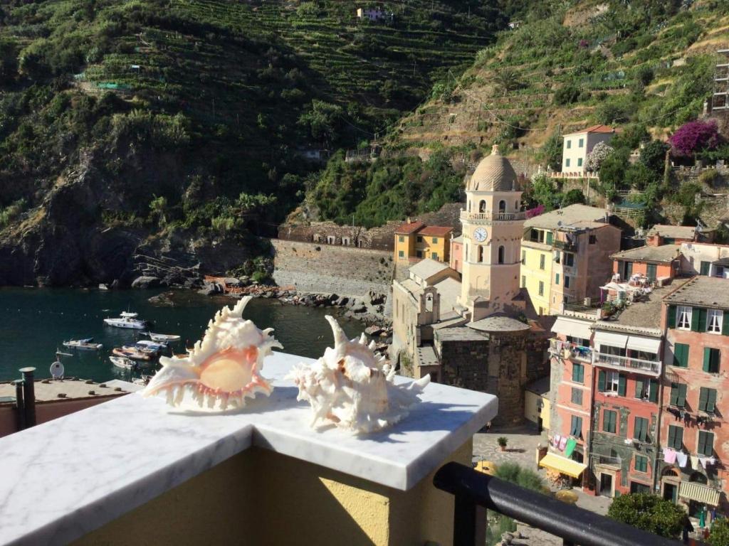 dos conchas de mar sentadas en la cima de una cornisa con una ciudad en Affittacamere Benedetta e Isabelle, en Vernazza
