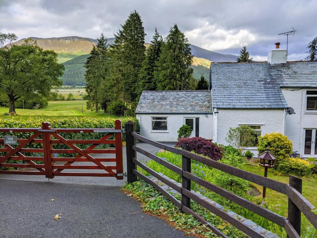 una valla de madera frente a una casa blanca en The Haven, en Keswick