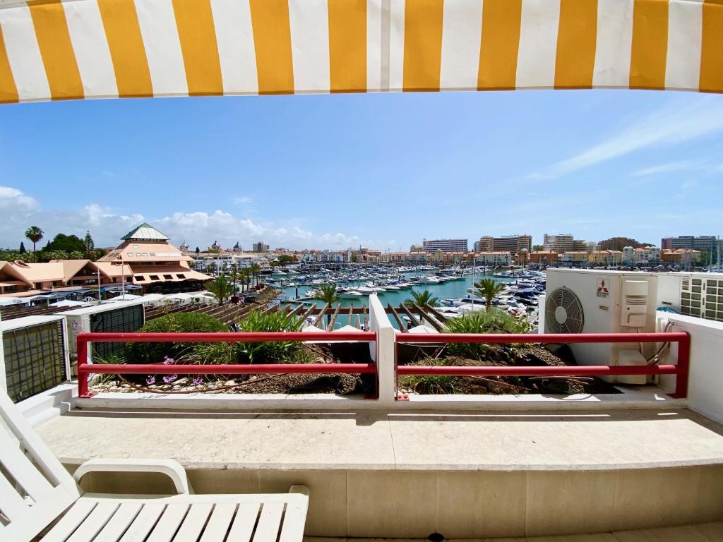 a balcony with a bench and a view of a harbor at Home Out Luxury Marina Apartment - 2 Bedrooms Sea View in Vilamoura