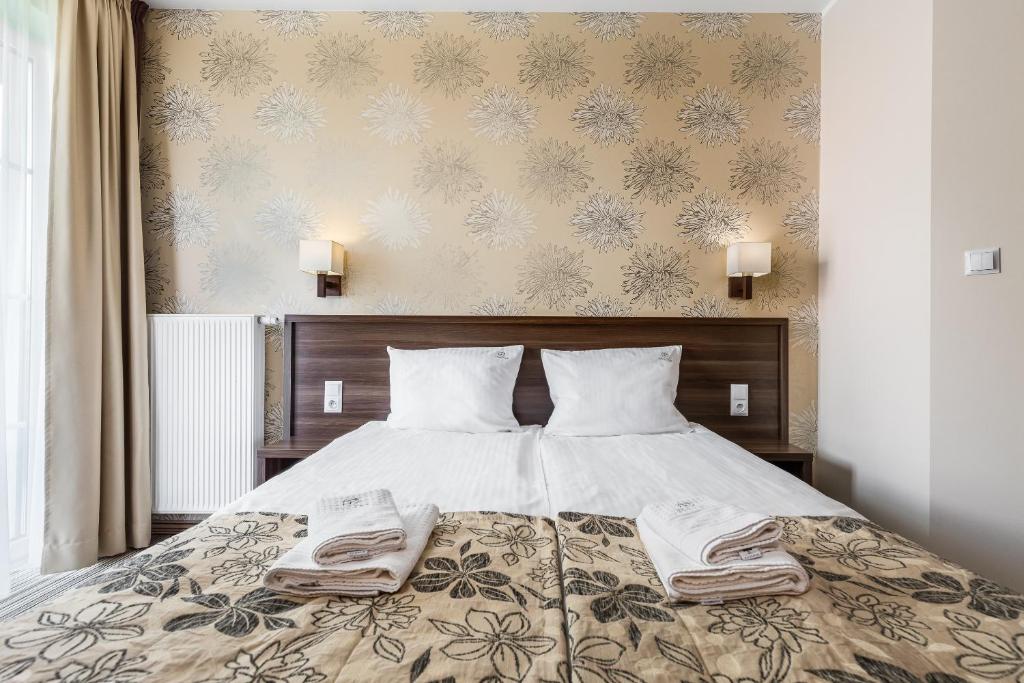 德茲維濟諾的住宿－帕里斯基旅館，一间卧室配有一张床,上面有两条毛巾