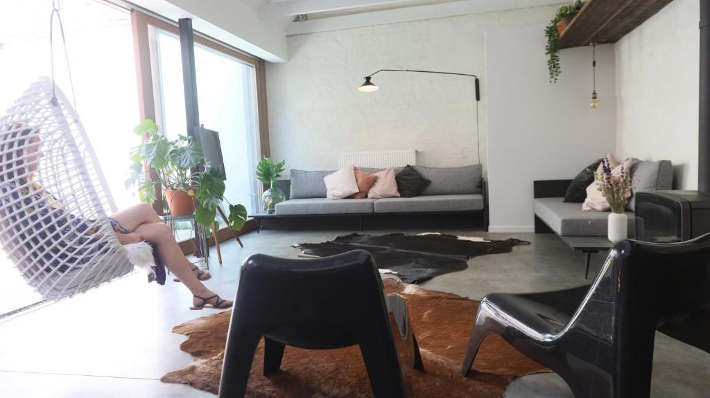 una sala de estar con un sofá y una silla en Maison Albert, en Nieuwpoort