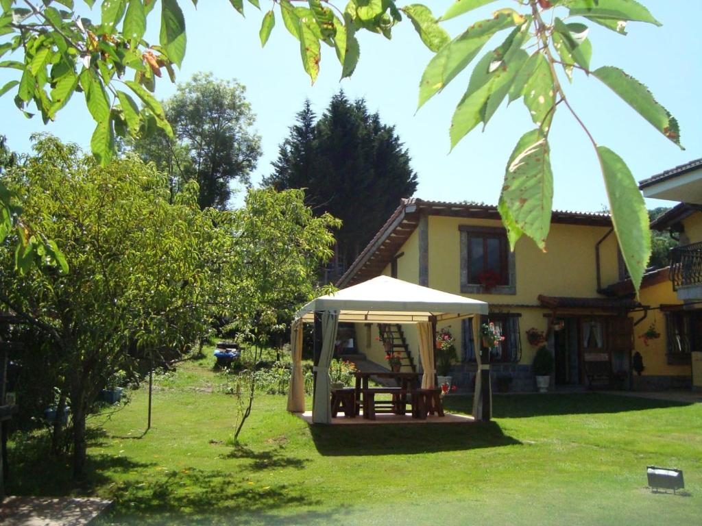 ein Haus mit einem Tisch und einem Zelt im Hof in der Unterkunft Apartamentos La Huerta de la Torre in Cangas de Onís
