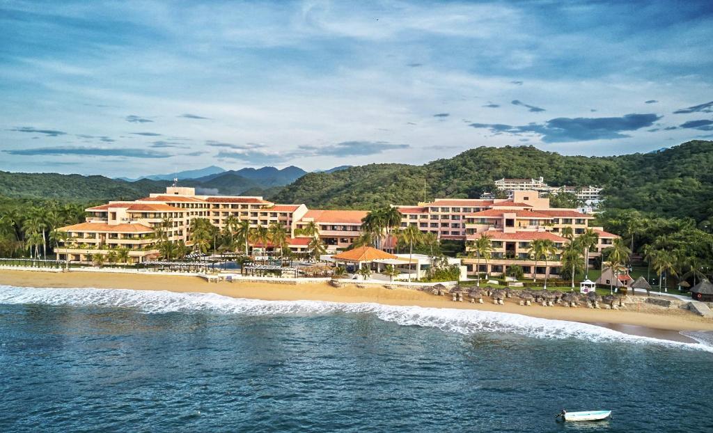 una spiaggia con un gruppo di hotel e persone su di essa di Barceló Huatulco a Santa Cruz Huatulco