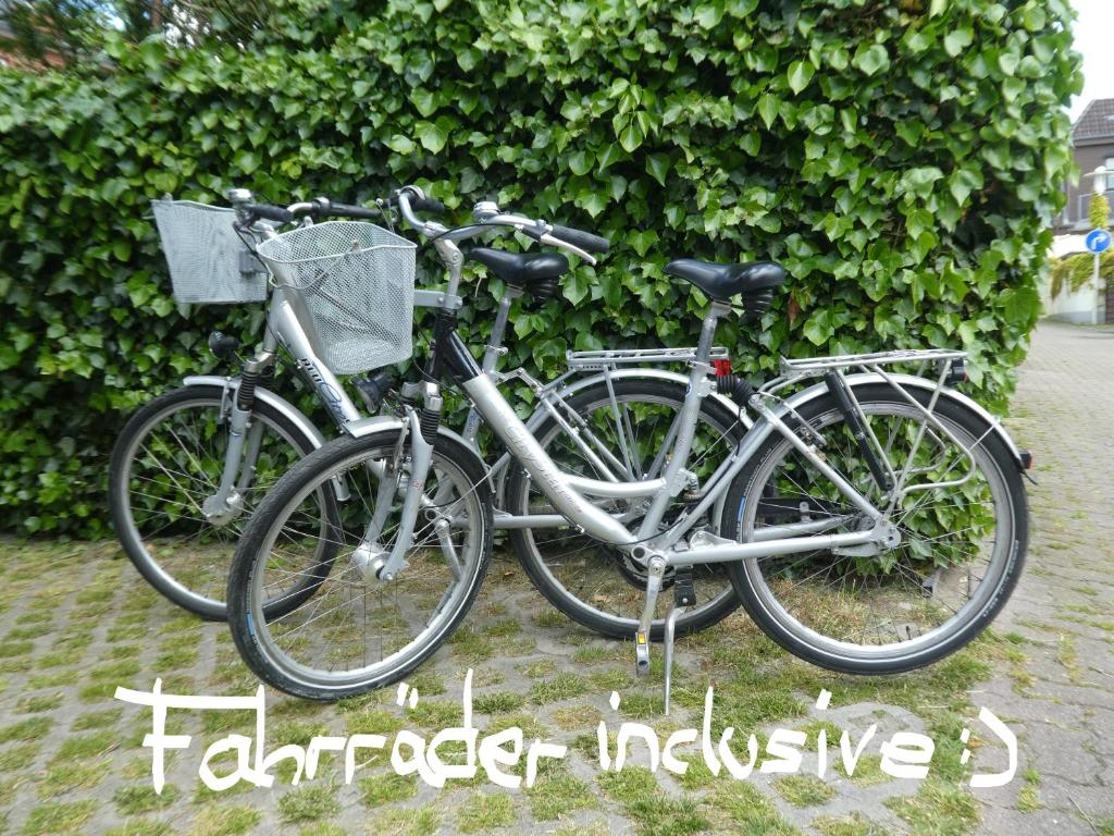 dos bicicletas estacionadas frente a un seto en Gästehaus Bei J.A.G., en Büsum