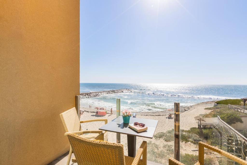 CortegaçaにあるVista Mare Beach Apartments by Destiny Housesのビーチの景色を望むバルコニー(テーブル、椅子付)