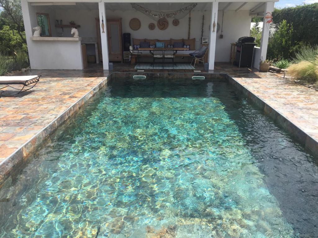 une grande piscine d'eau claire dans une arrière-cour dans l'établissement mazet provençal, à Saint-Gilles