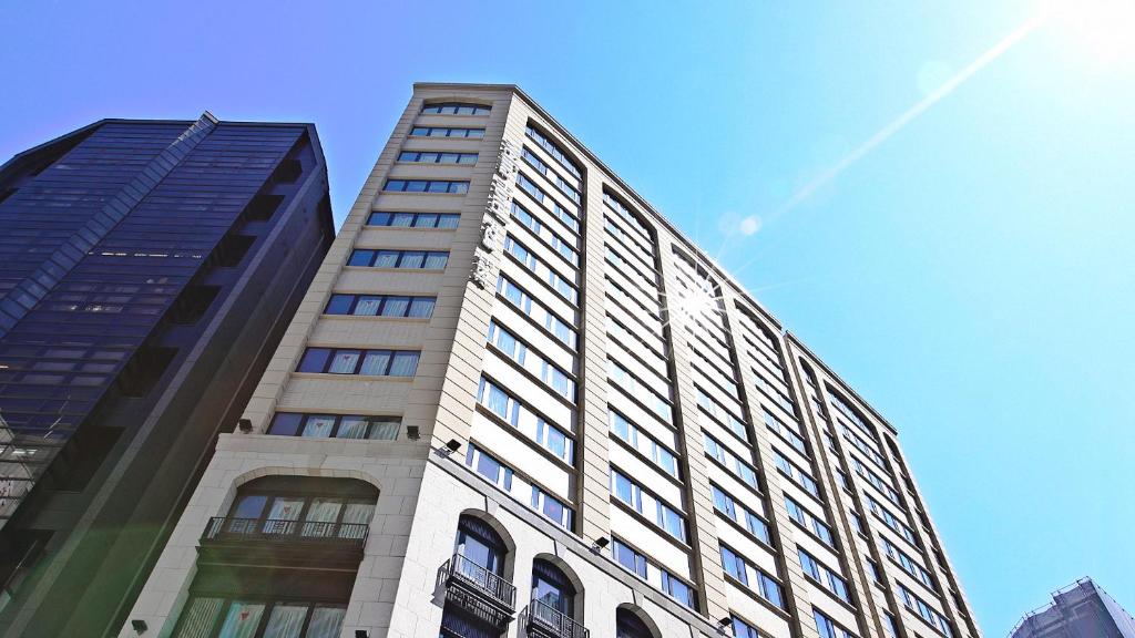 a tall building in front of a blue sky at Welina Hotel Premier Nakanoshima EAST in Osaka