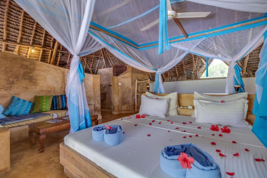 マテムウェにあるSeVi Boutique Hotelの赤い花が飾られたベッドのある寝室
