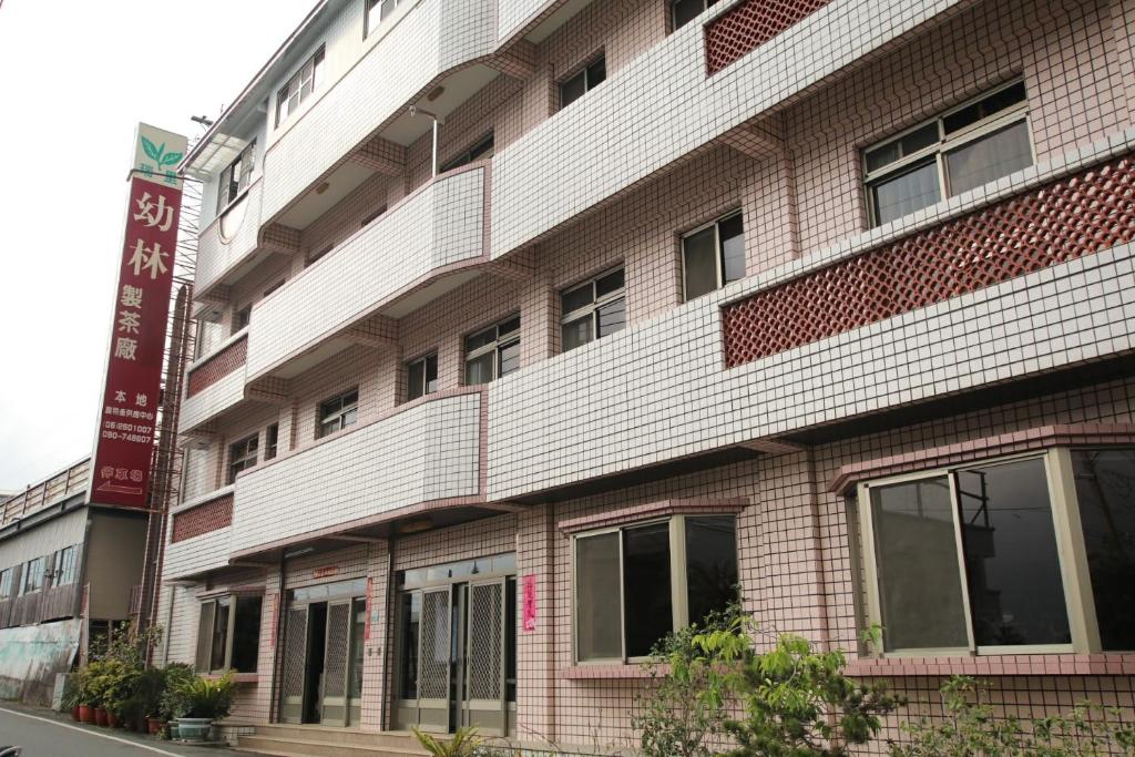 a large brick building with windows on a street at Youlin Homestay in Meishan