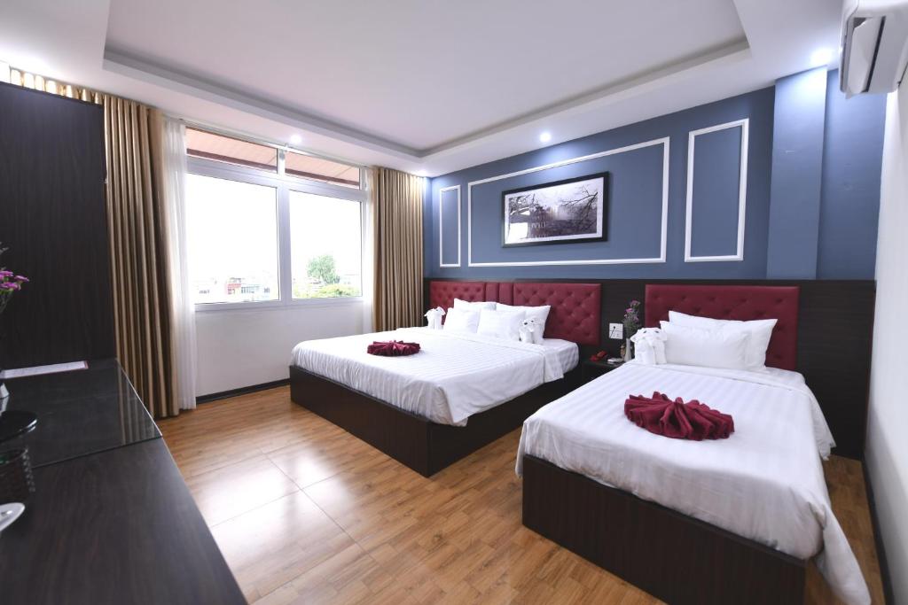 Postel nebo postele na pokoji v ubytování Hanoi Elpis Grand Hotel
