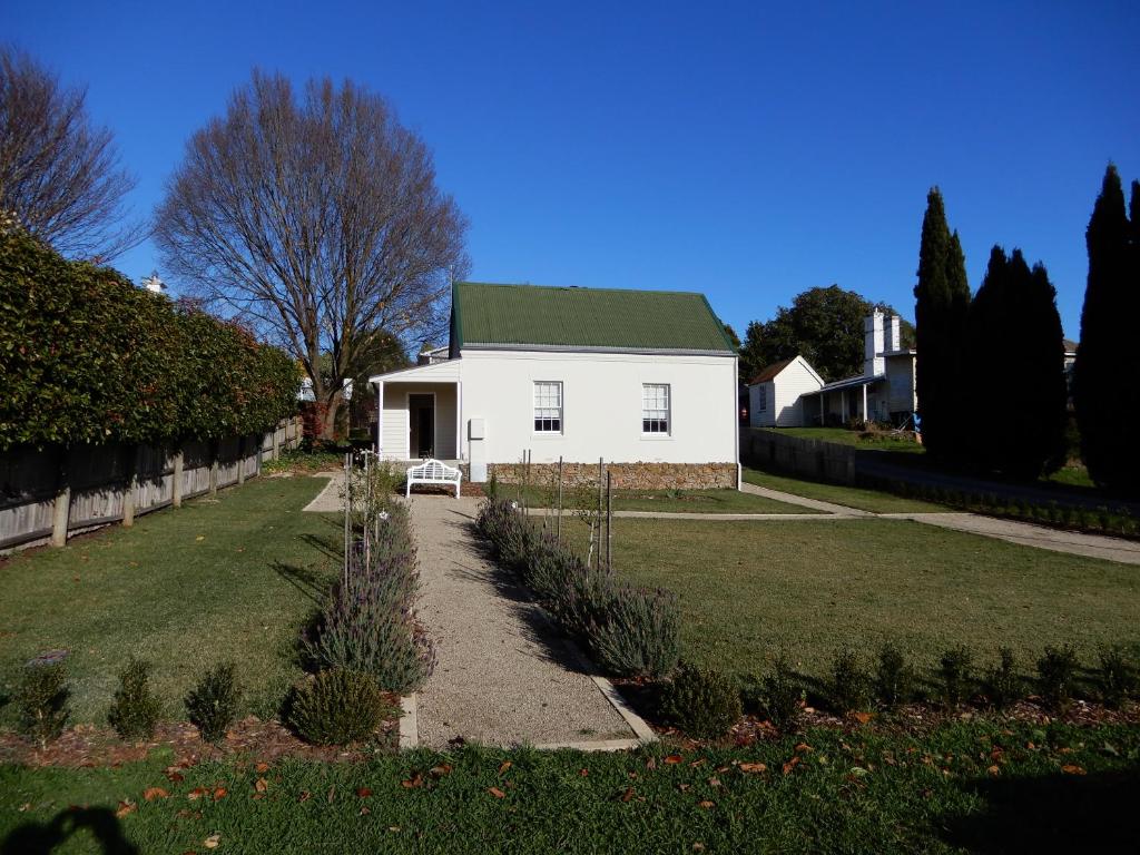 a white house with a green roof in a yard at The Chapel Deloraine in Deloraine