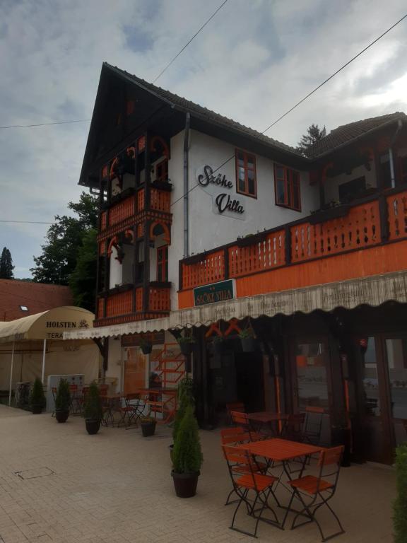 un restaurante con mesas y sillas frente a un edificio en VILA SZOKE SOVATA en Sovata