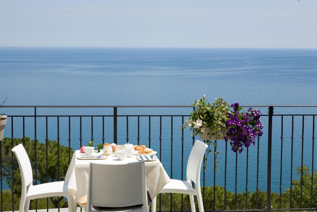 a table and chairs with a view of the ocean at Diecidodici BoutiqueRooms in Sirolo