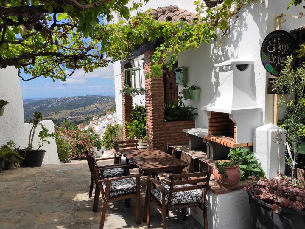 a wooden table and chairs outside of a building at El hogar de Lucía in Casares