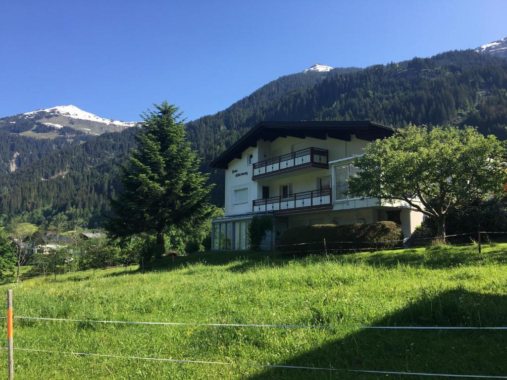 ein Haus auf einem Hügel mit Bergen im Hintergrund in der Unterkunft Haus Silberwang in Sankt Gallenkirch