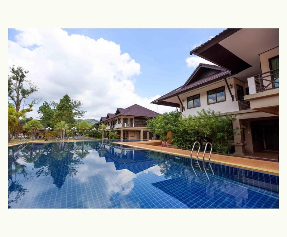 a swimming pool in front of a house at Sophia Resort in Ban Wang Takhrai