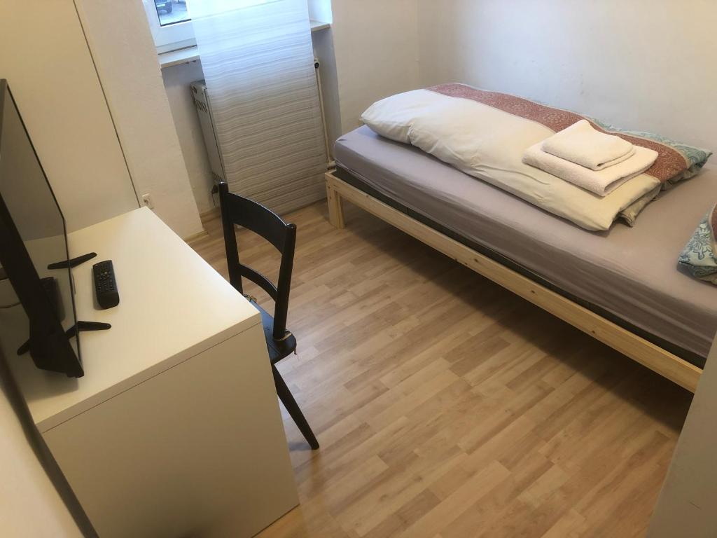 a small room with a bed and a desk and a chair at Wallnuss in Alzenau in Unterfranken