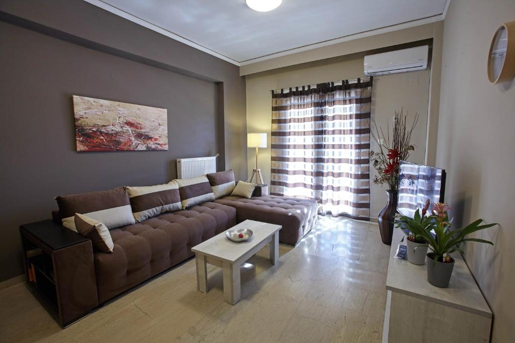 - un salon avec un canapé et une table dans l'établissement C.L.A. City Loux Apartment, à Alexandroúpolis