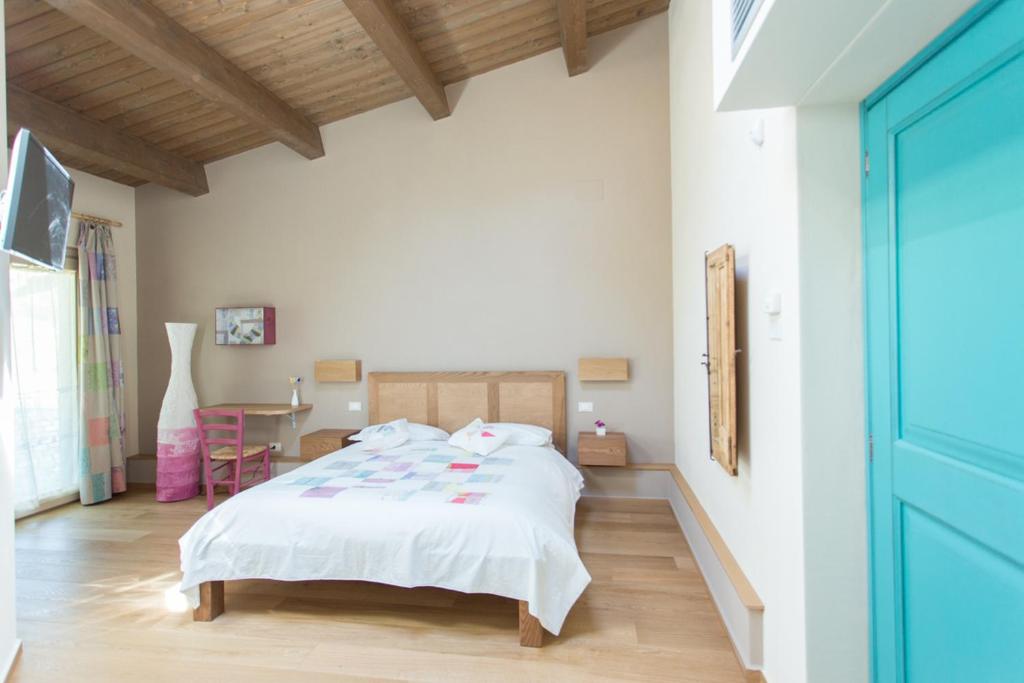 1 dormitorio con cama blanca y mesa en Agriturismo Castelli In Aria, en Atri