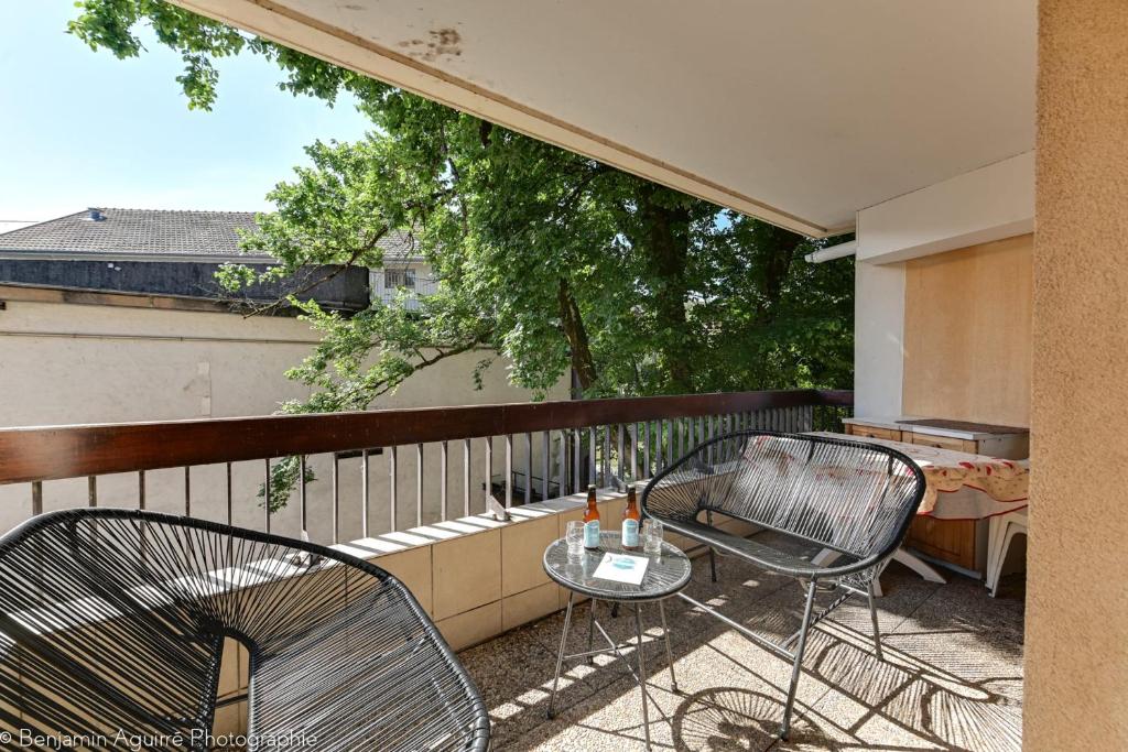 een patio met 2 stoelen en een tafel op een balkon bij Le Vassé - Apartment 2 Bedrooms with terrace - pedestrian area in Annecy