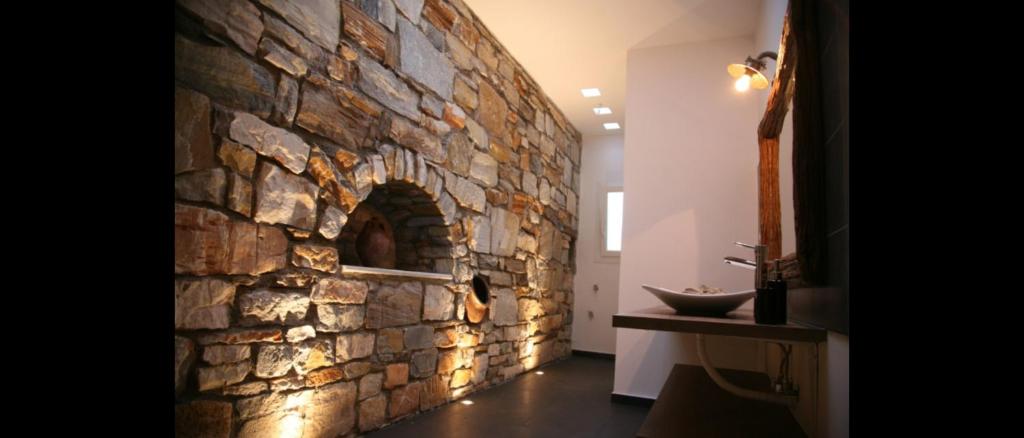 pared de piedra en un pasillo con lavabo en Chez Kiki et Ioannis, en Naxos Chora
