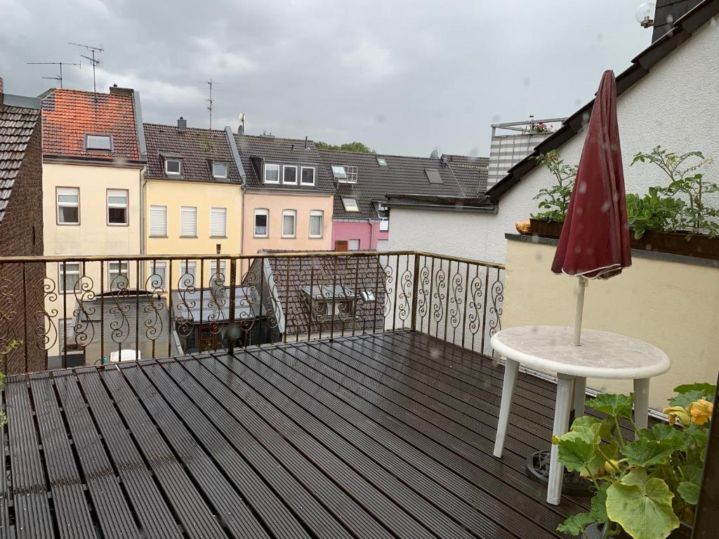 a patio with a table and an umbrella on a balcony at Wohnung Dachterrasse 3 in Brühl