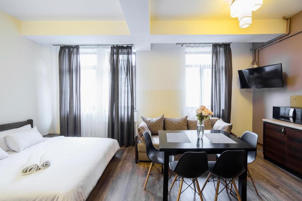 a hotel room with a bed and a table and chairs at Аpartments in the center (Mytna square) in Lviv