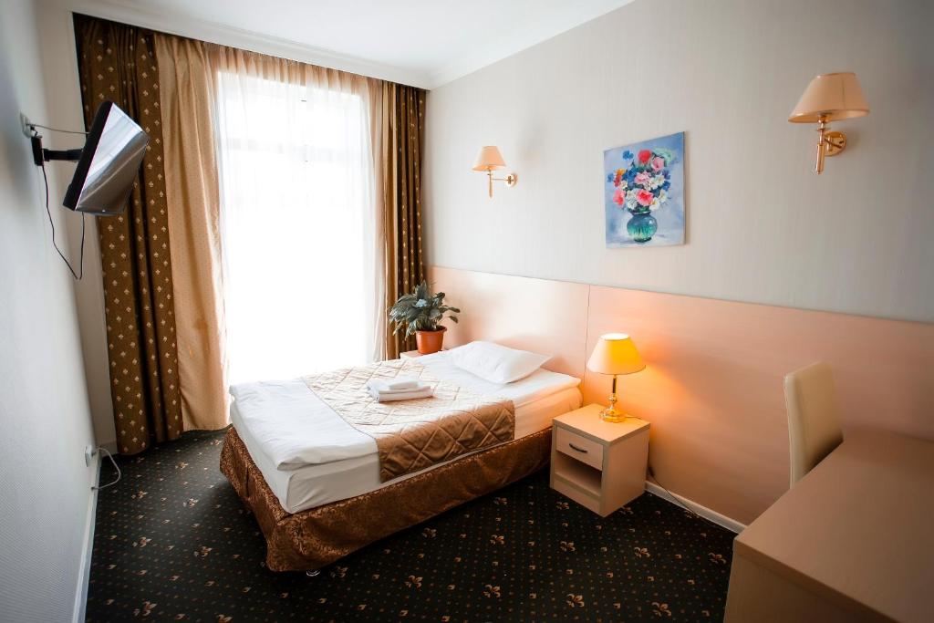ein Hotelzimmer mit einem Bett und einem Fenster in der Unterkunft SKYVersal in Astana