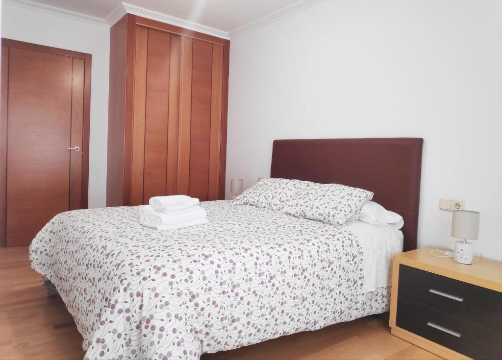 um quarto com uma cama e um armário de madeira em Apartamento Naval em Marín