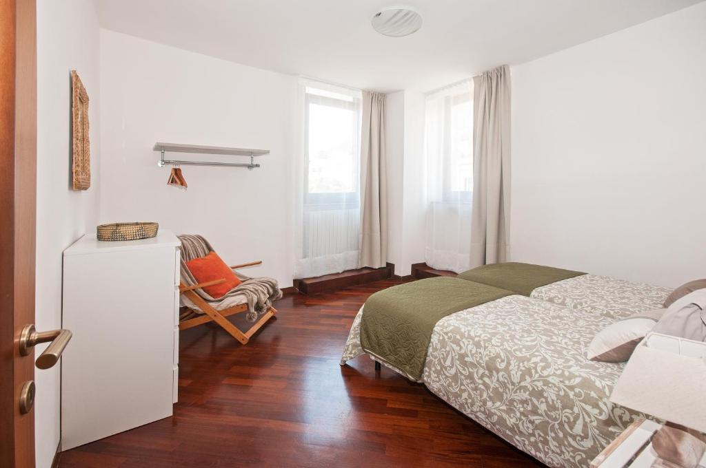 a bedroom with a bed and a chair in it at Casa Regina in Salò