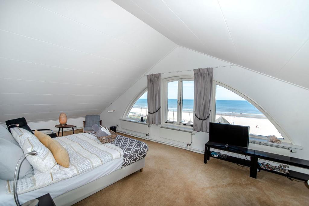 a living room with a bed and a large window at 't Spokeduin in Zandvoort