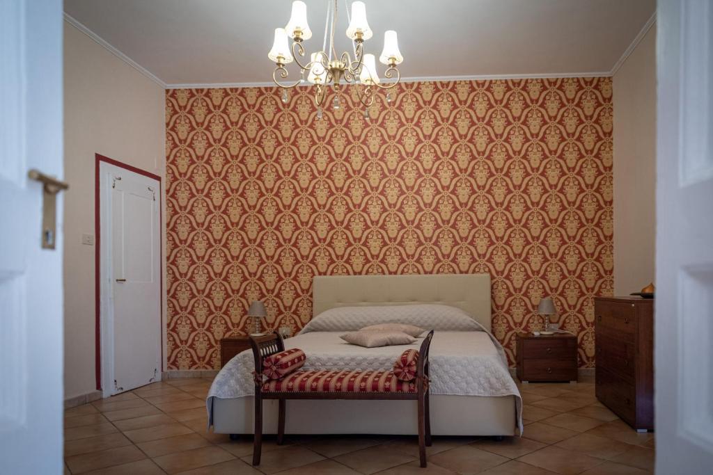 una camera con letto e lampadario a braccio di L'Antica Caiatia a Caiazzo