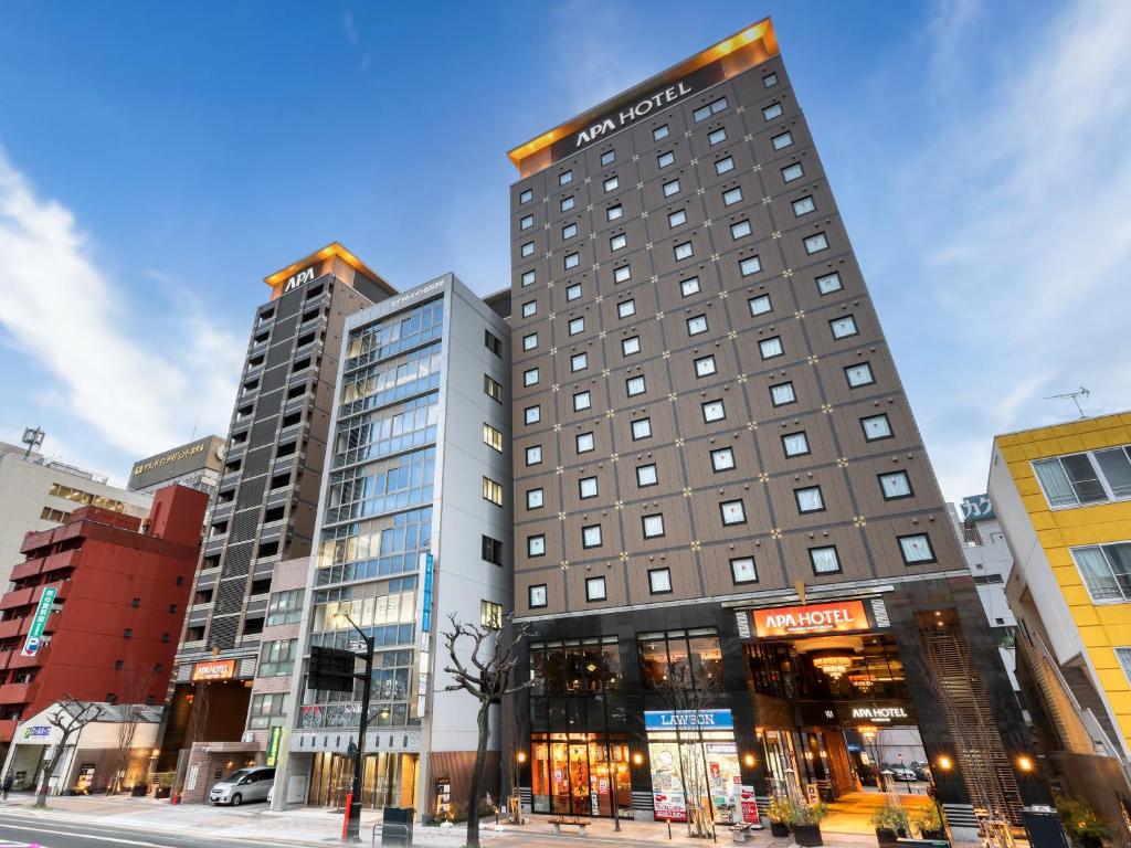 un edificio alto en una calle de la ciudad con edificios en APA Hotel Hiroshima-Ekimae Ohashi en Hiroshima