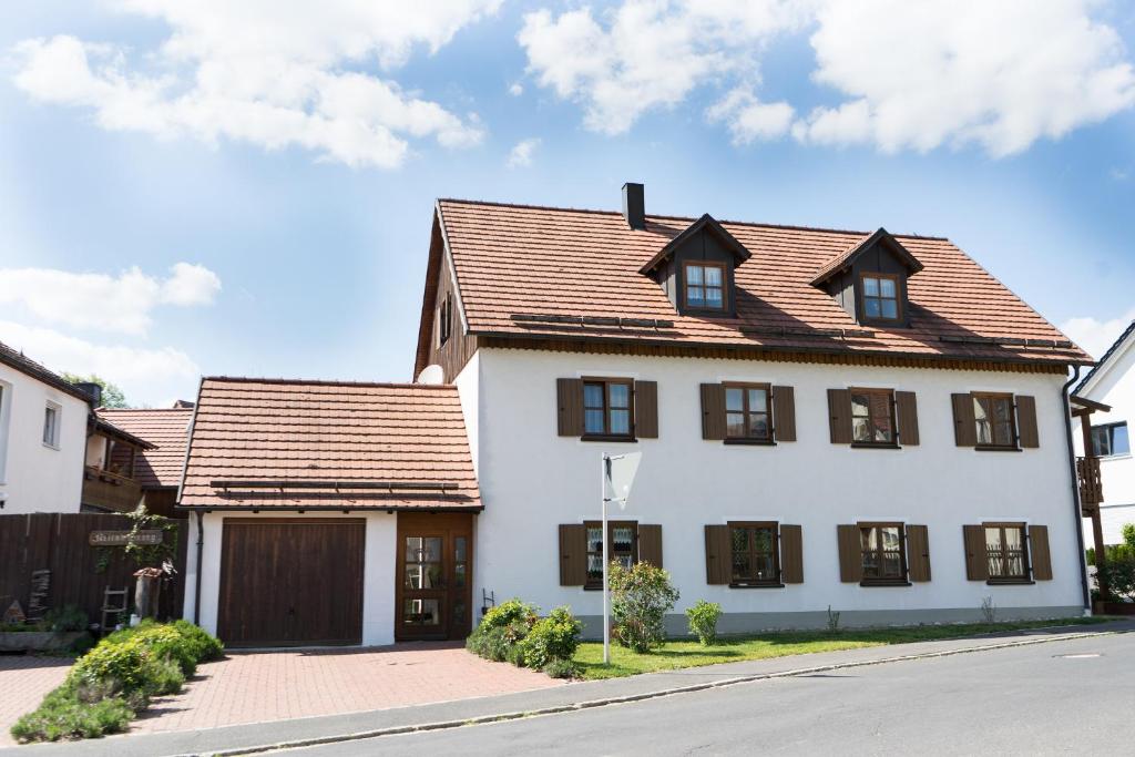 une maison blanche avec un toit marron dans l'établissement Ferienwohnungen Köhler, à Neualbenreuth