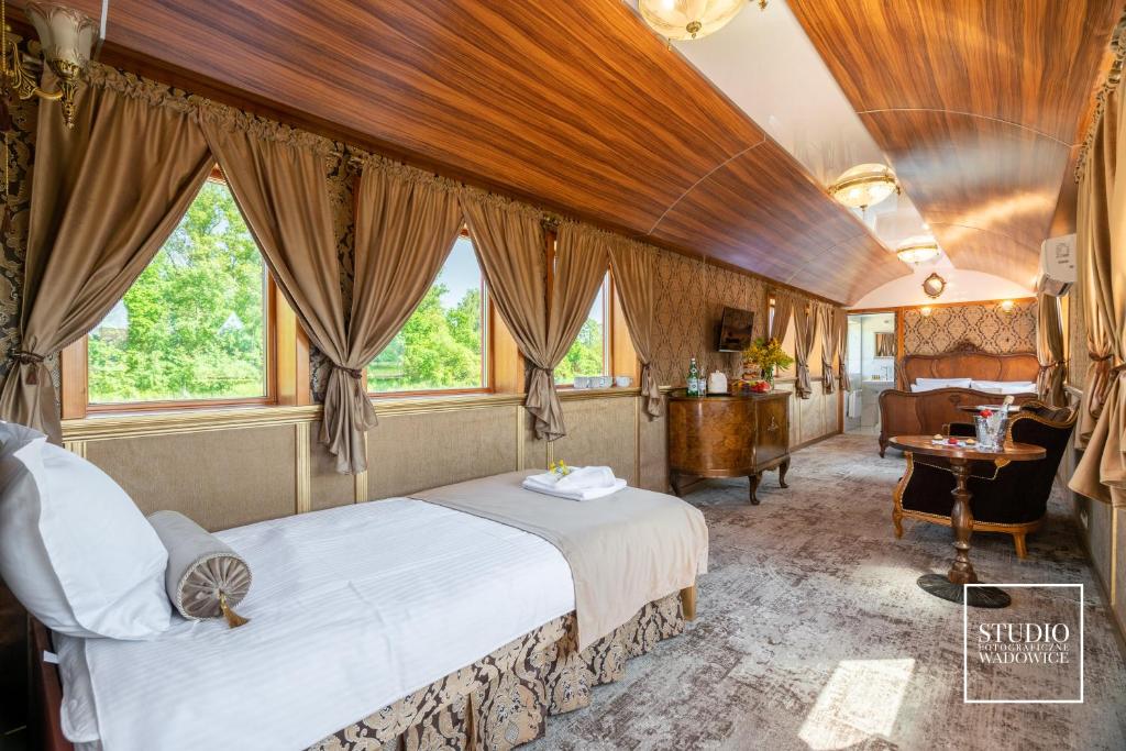 a bedroom with a bed in a room withwindows at Stacja Galicja - nocleg w pociągu blisko Energylandia in Zator
