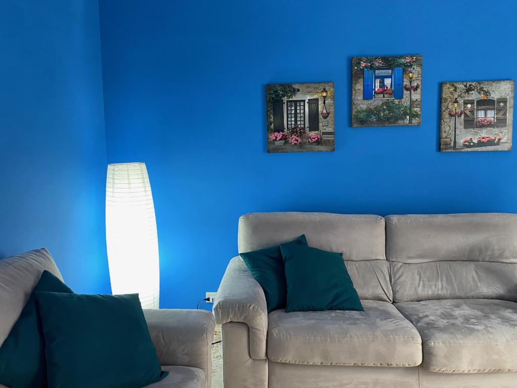 sala de estar con sofá y pared azul en Relax in Taranto en Taranto