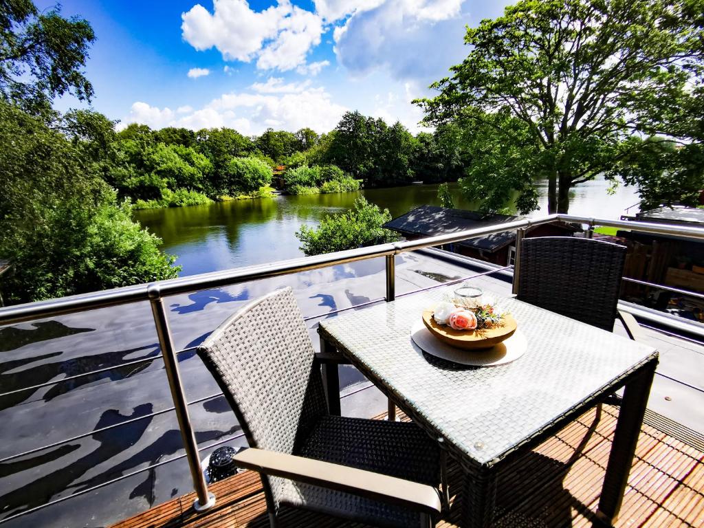 einen Tisch und Stühle auf einer Terrasse mit Flussblick in der Unterkunft Auszeit Norddeich mit Seeblick in Norddeich