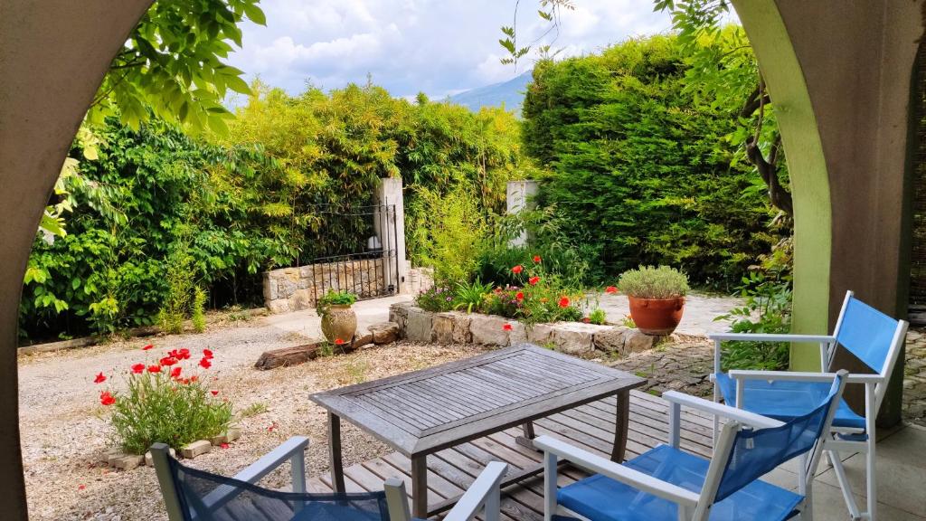 a patio with a table and chairs and flowers at Bambou entre Mer et Montagnes in Châteauneuf