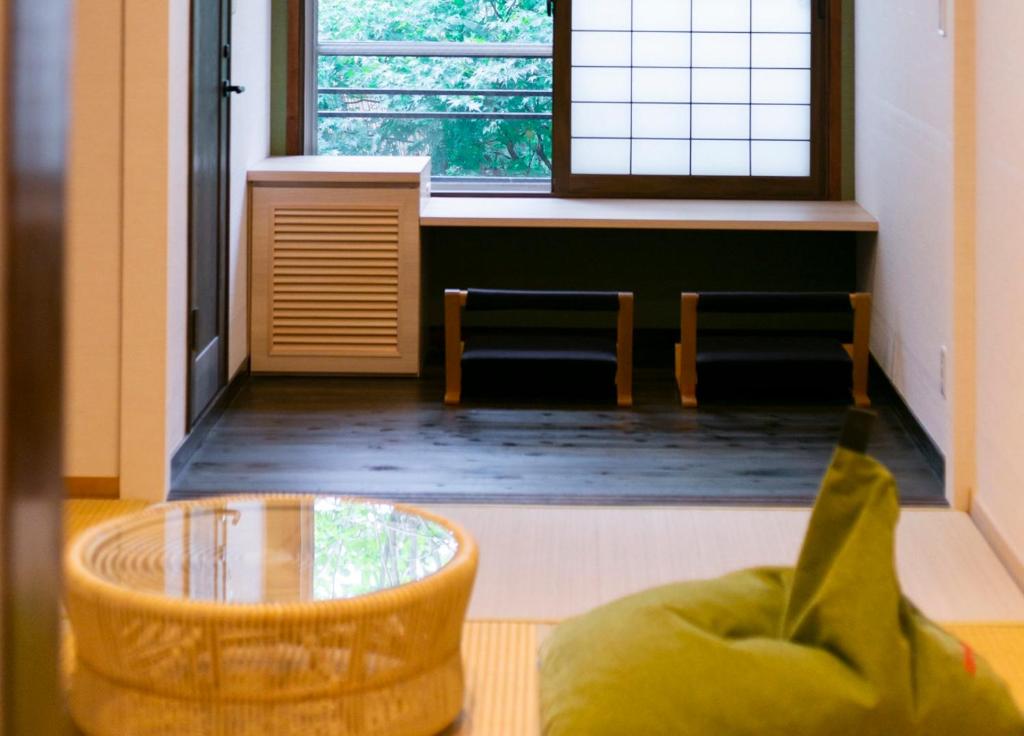 a room with a table and chairs and a window at Ryokan Yoshidaya in Ureshino