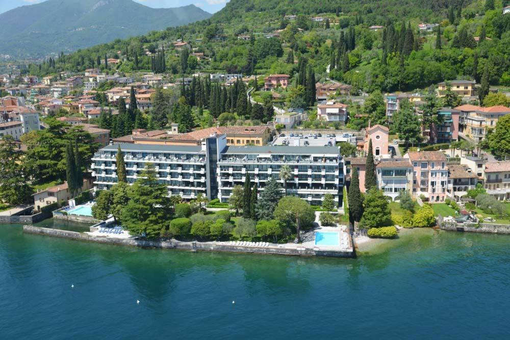 a large building on an island in the water at Appartamento direttamente a lago - Ben Approved in Salò