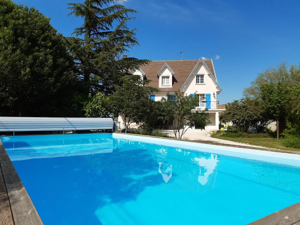 een groot blauw zwembad voor een huis bij La maison bleue in Corpeau