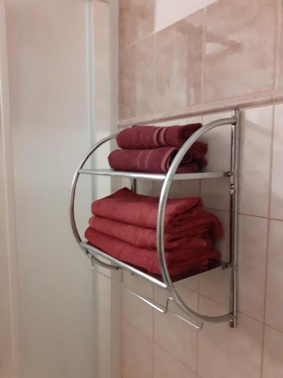 un portasciugamani in bagno con asciugamani rossi di Penzion Fontána a Mikulov