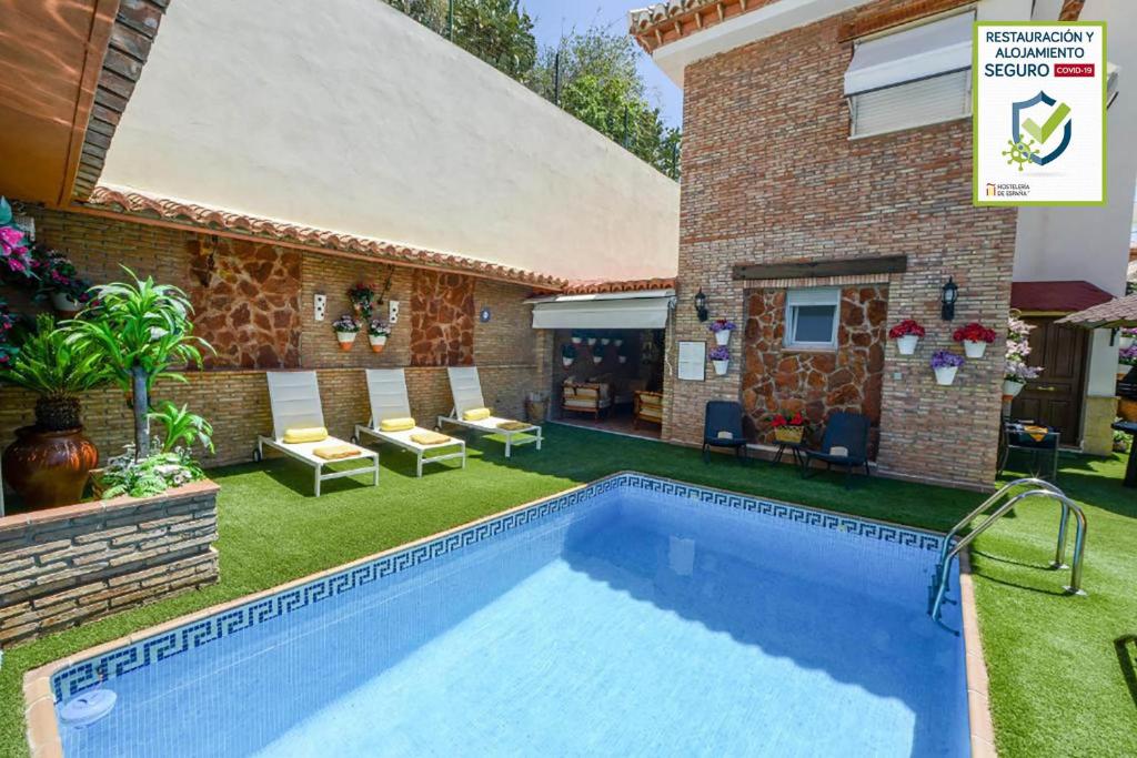 einen Pool im Hinterhof eines Hauses in der Unterkunft Apartamentos Turísticos Tronca Luxury in Granada