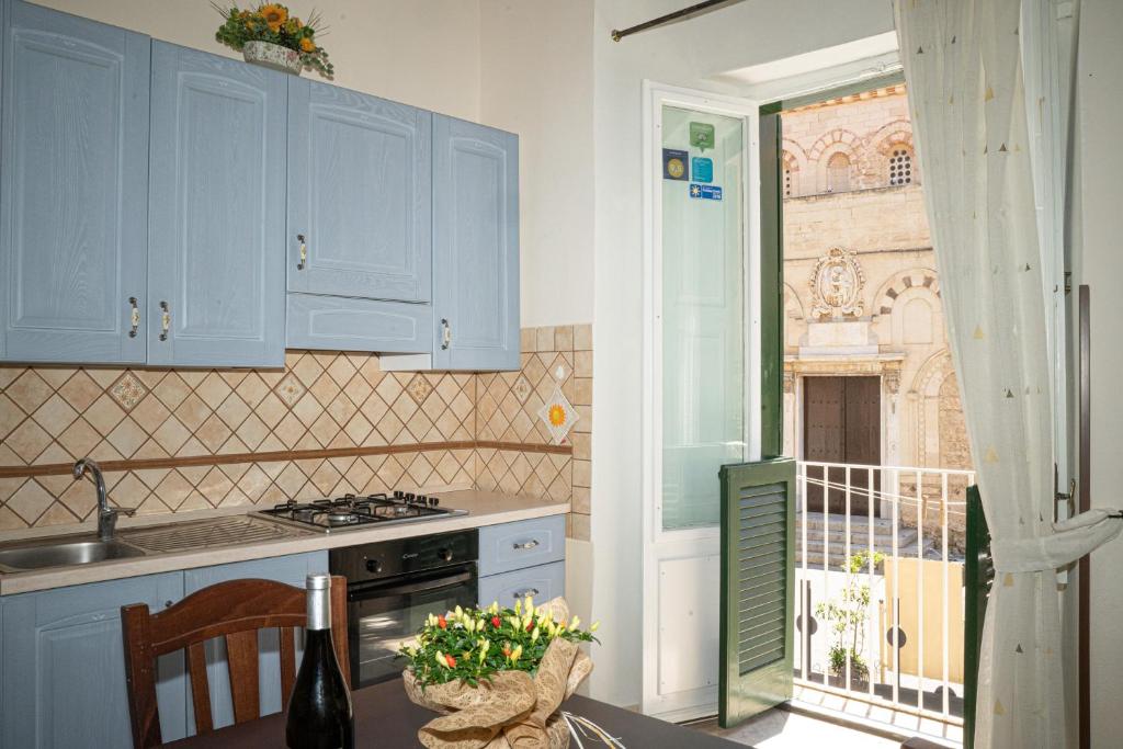 une cuisine avec des placards bleus et une table avec un évier dans l'établissement Palazzo Tranfo Al Duomo Accommodation, à Tropea