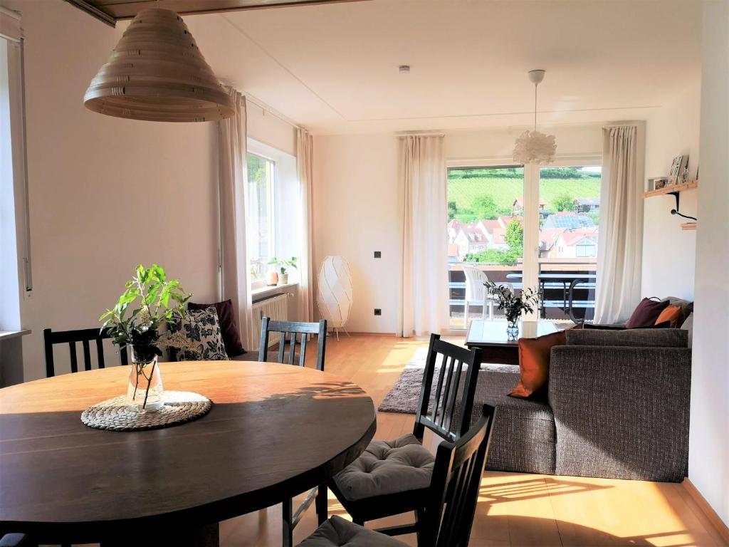 sala de estar con mesa de madera y comedor en Ferienwohnung "Burgpanorama" in der Südpfalz, en Leinsweiler