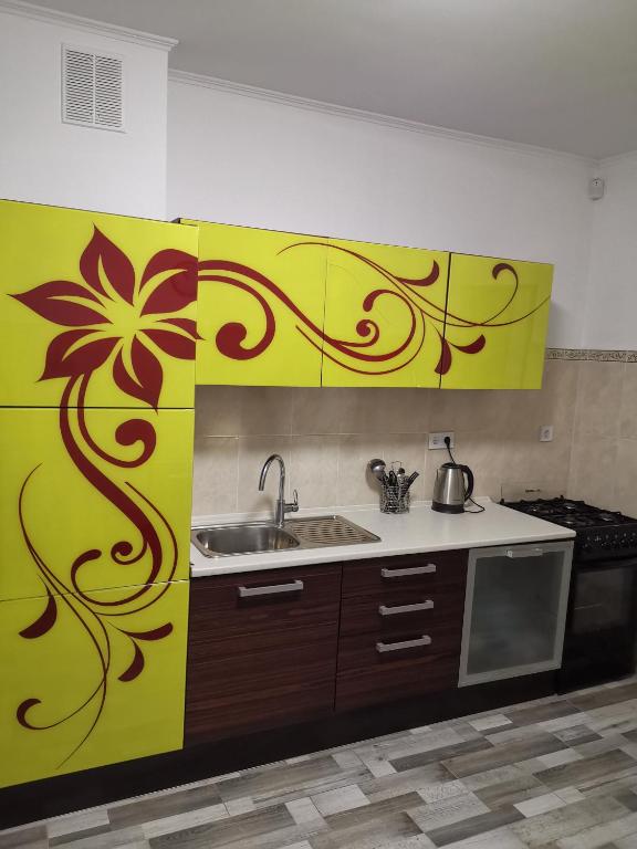 a kitchen with a yellow wall with a flower on it at Номер в приватному будинку in Morshin