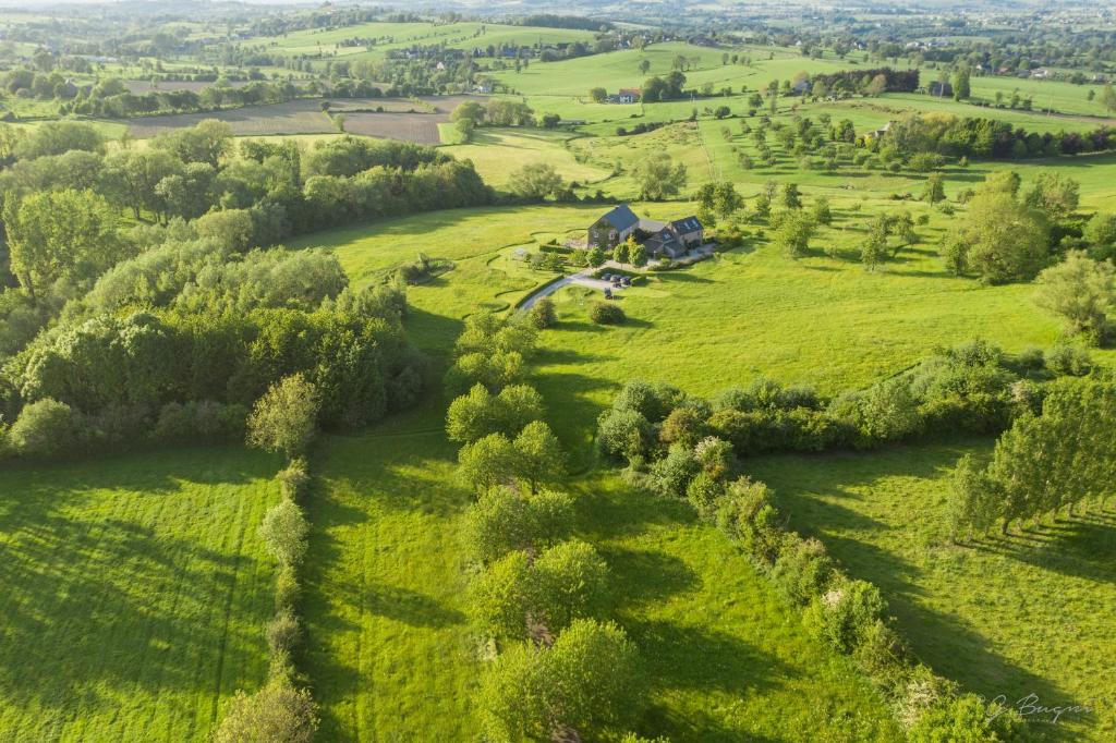 an aerial view of a green field with a house at côté verger B&B in Battice