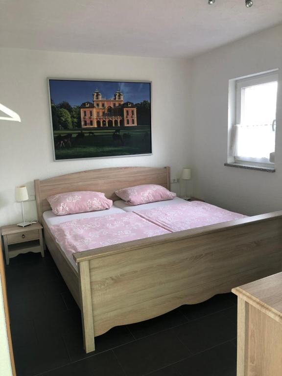 Un dormitorio con una gran cama de madera con sábanas rosas. en Gästehaus Glock II, en Marbach am Neckar